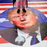 Учасники протестів руху No Kings у США тримають плакати на захист виборчих прав і проти політики Дональда Трампа.